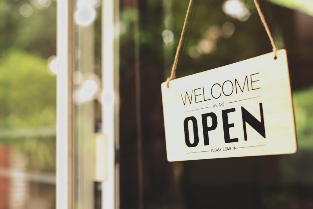 A business sign that says "Open" on cafe or restaurant hang on door at entrance.