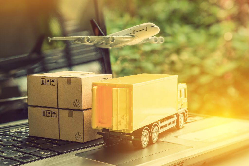 Air courier / freight forwarder or shipping service concept : Boxes, a truck, white plane flies over a laptop, depicts customers order things from retailer sites via the internet and ship worldwide– captive insurance supply chain crime